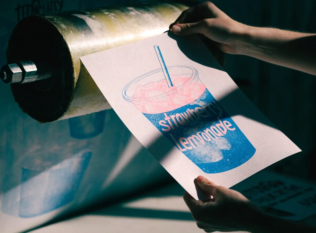 Strawberry lemonade in a clear cup with condensation on a flat surface